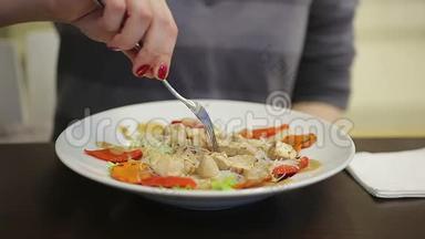 年轻女士吃开胃的鸡肉和蔬菜沙拉，保持健康的饮食